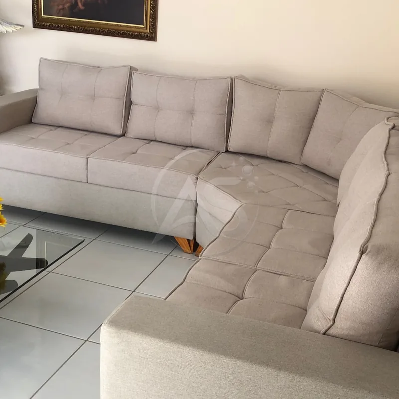 Sofá de canto em tecido cinza claro higienizado na sala do cliente
